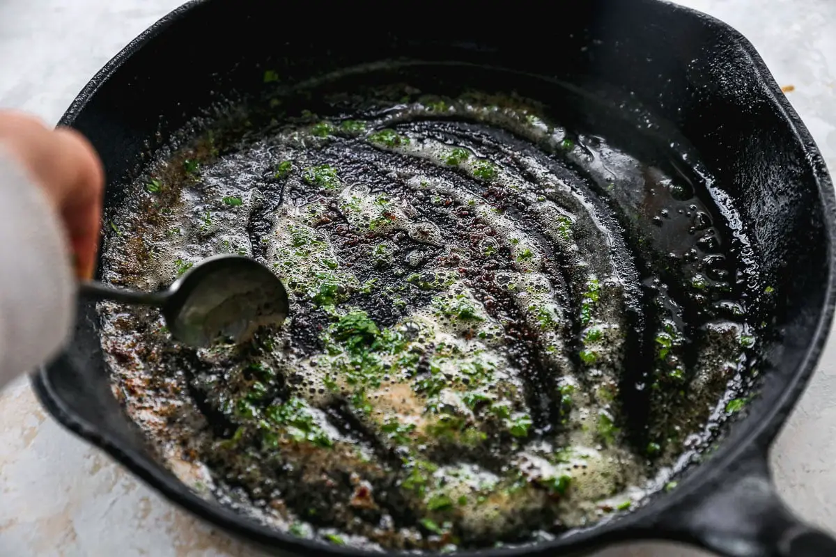 Petersilie in die Pfanne der Butter hinzugefügt