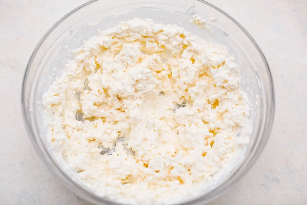 Overhead shot of cottage cheese, mozzarella, sour cream and cream cheese mixed together. 