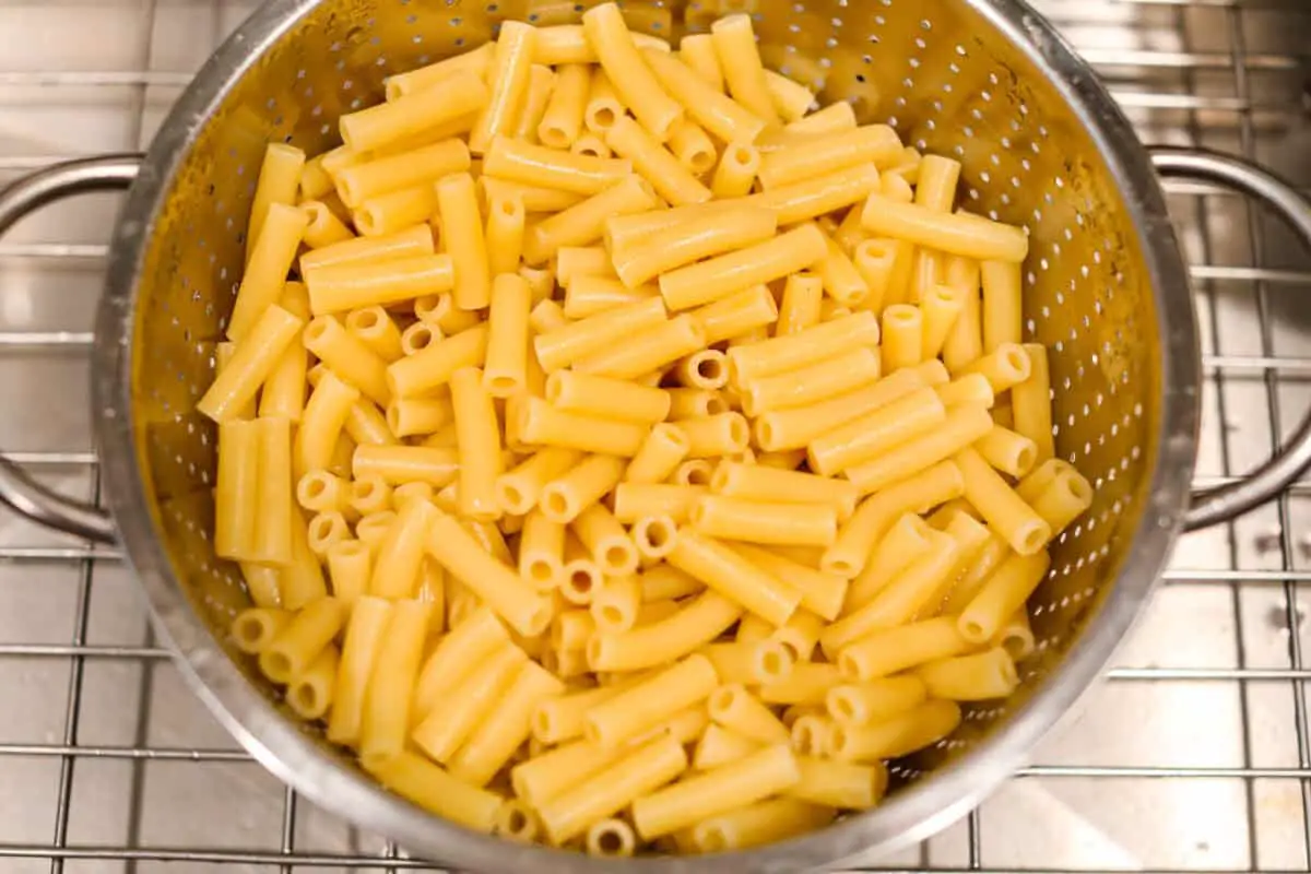 Overhead shot of cooked ziti noodles in a colander. 