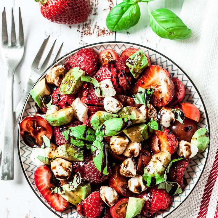 Erdbeer-Caprese-Salat auf Tellern angerichtet und garniert.