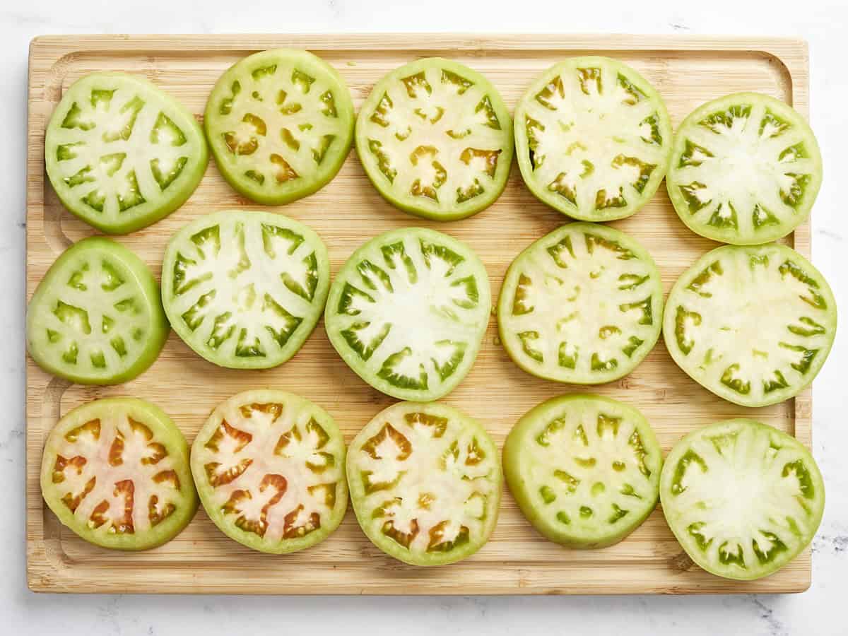 geschnittene grüne Tomaten auf einem Schneidebrett.