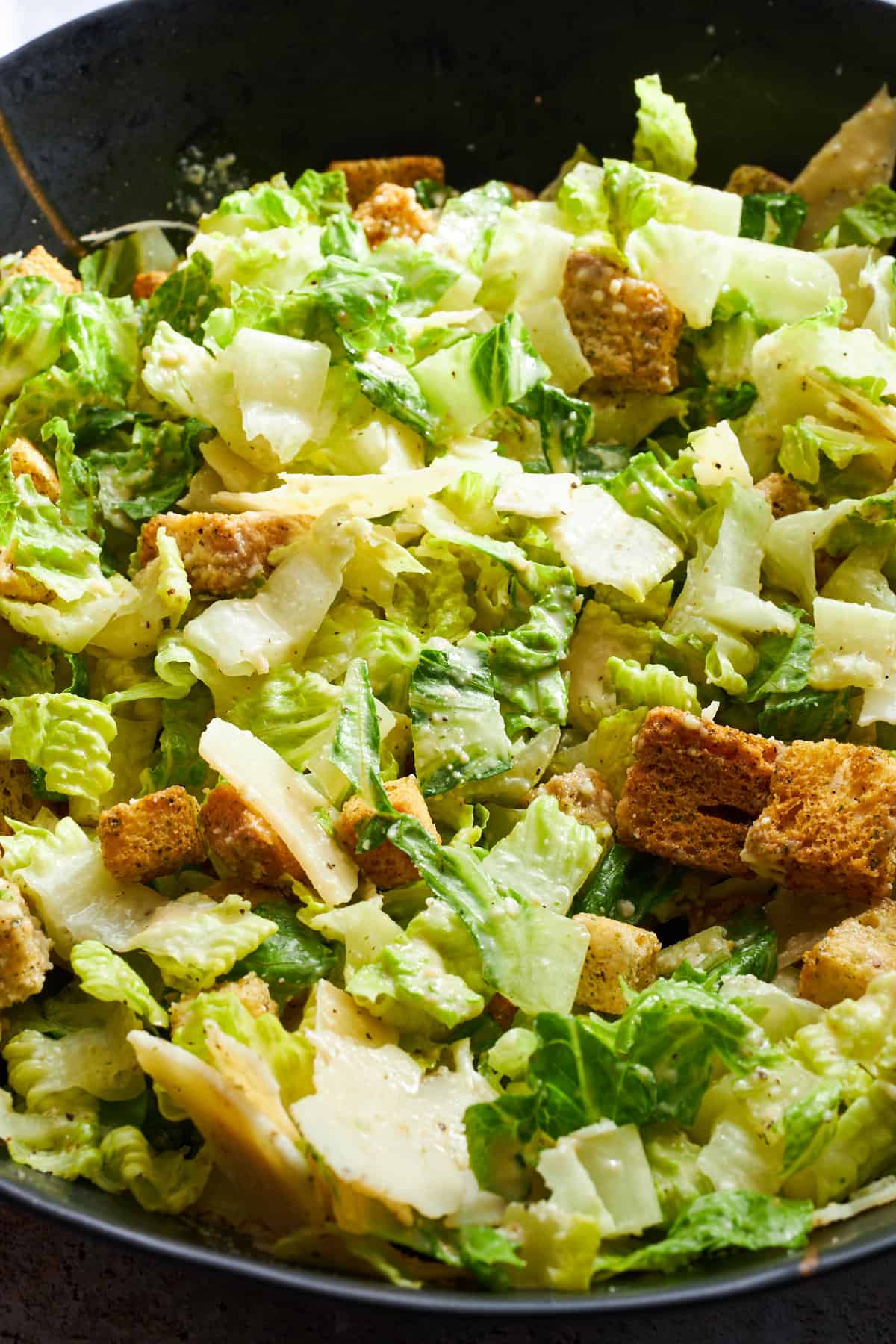 Nahaufnahme eines Caesar-Salats mit Dressing. 