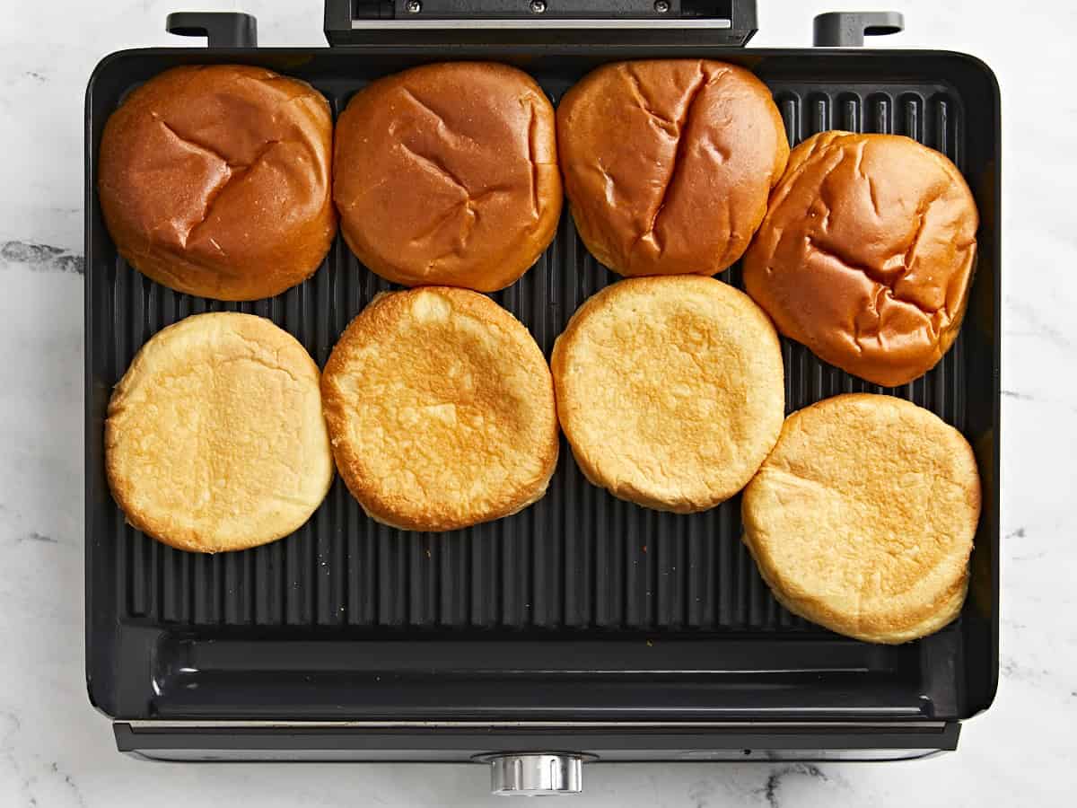 Hamburgerbrötchen auf einem Grill toasten.