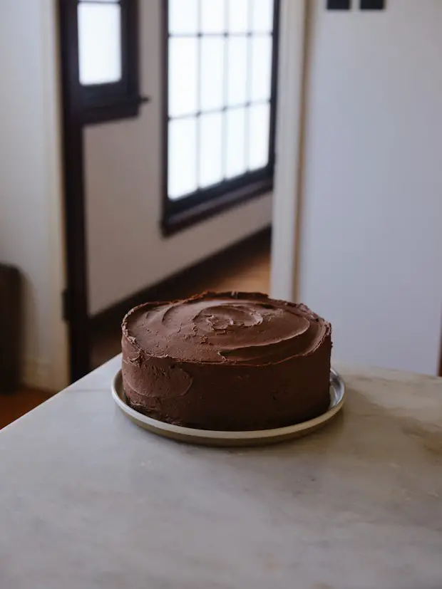 gelber Kuchen mit Schokoladenglasur auf einer Theke in einer Küche