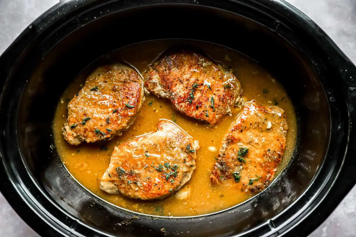 Schweinekoteletts und Soße in einem Crockpot.