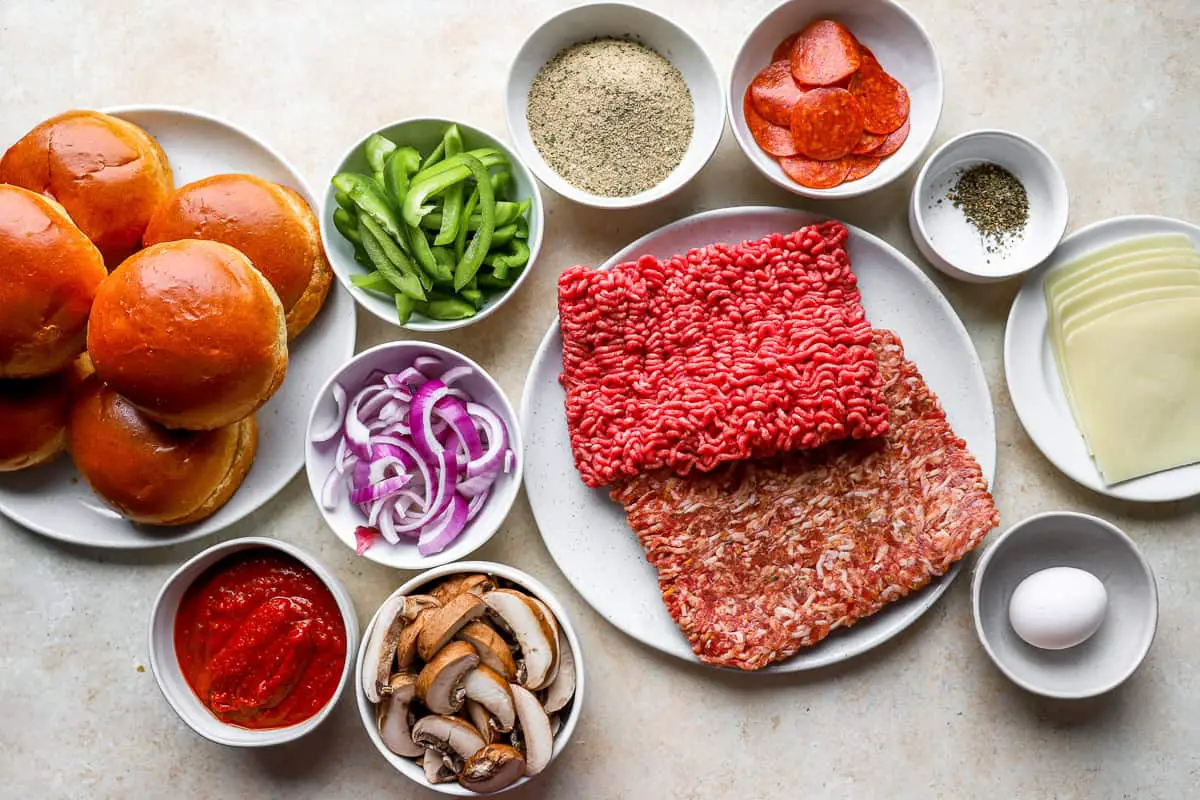 ein Teller Hamburgerbrötchen mit Fleisch, Zwiebeln und anderen Zutaten.