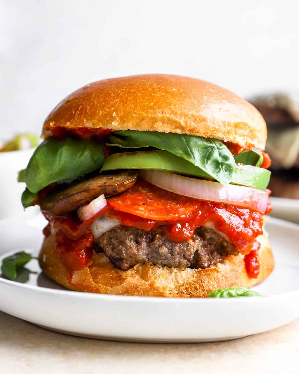 a burger on a plate with tomatoes, lettuce, and other toppings.