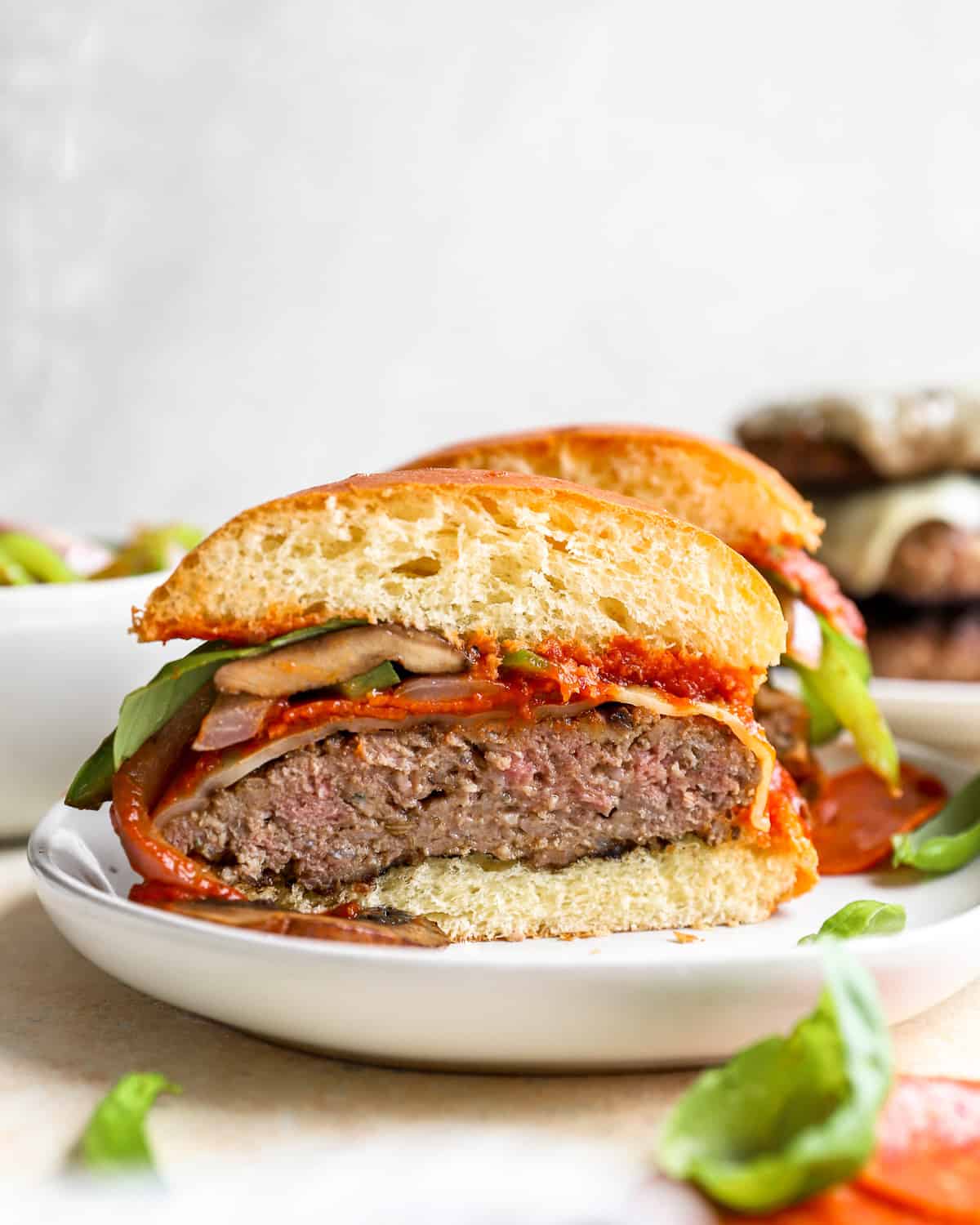 ein halbierter Burger aus Rindfleisch und italienischer Wurst auf einem Teller.