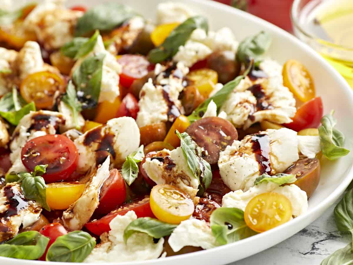 Caprese-Salat auf einem weißen Servierteller.