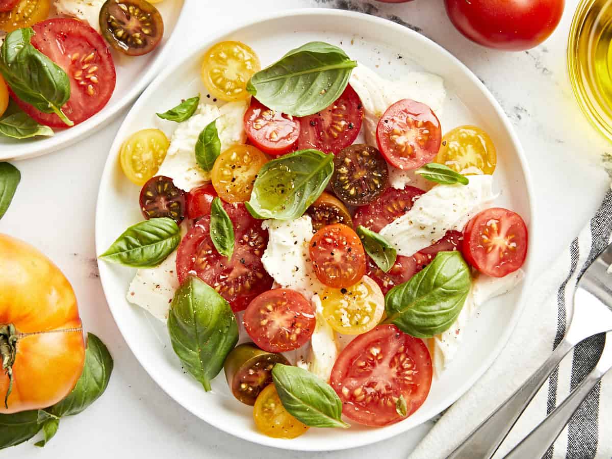 Draufsicht auf eine Portion Caprese-Salat auf einem weißen Teller.