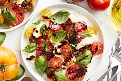 overhead view of a serving of caprese salad on a white plate with balsamic glaze.