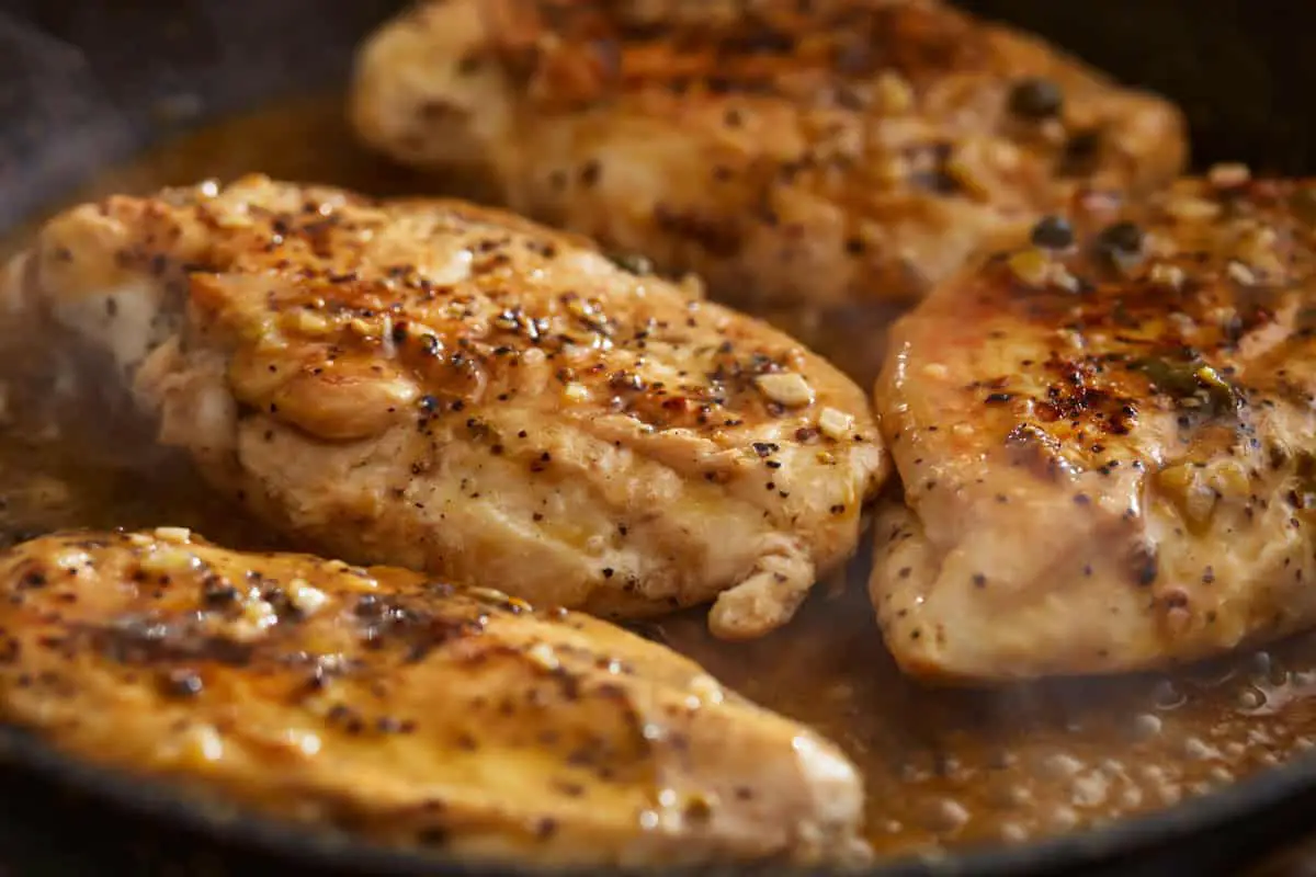 Nahaufnahme von Zitronenpfeffer-Hühnchen in einer Pfanne.