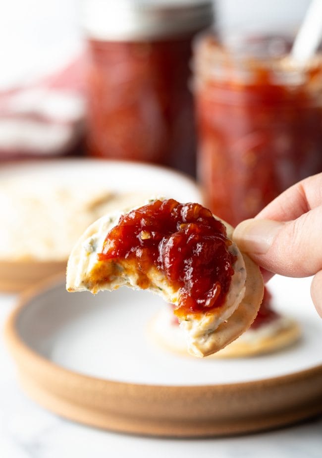 Ein Bissen Cracker mit Käse und hausgemachter Marmelade aus Tomaten.