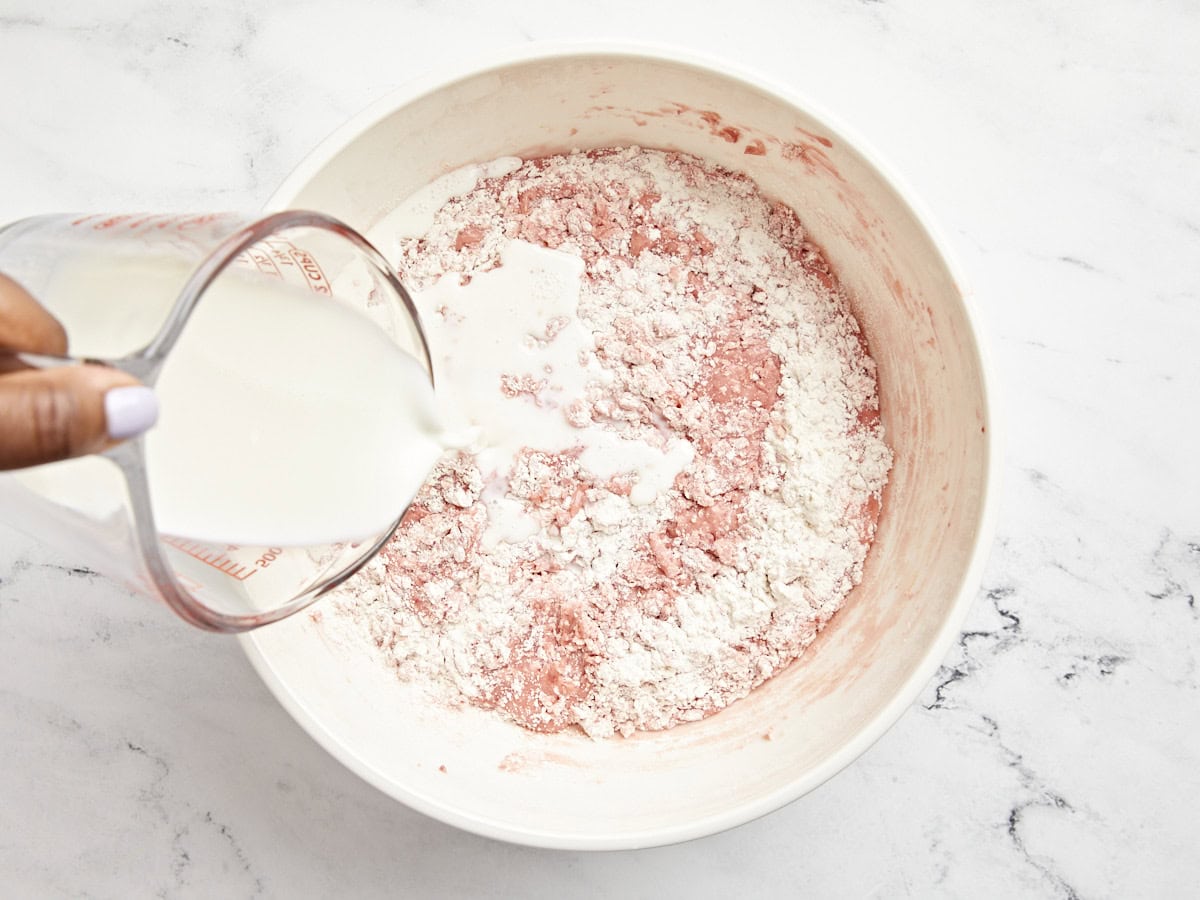 Milch in die Schüssel mit dem Kuchenteig geben.