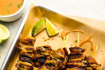 thai grilled chicken with peanut sauce on tray.