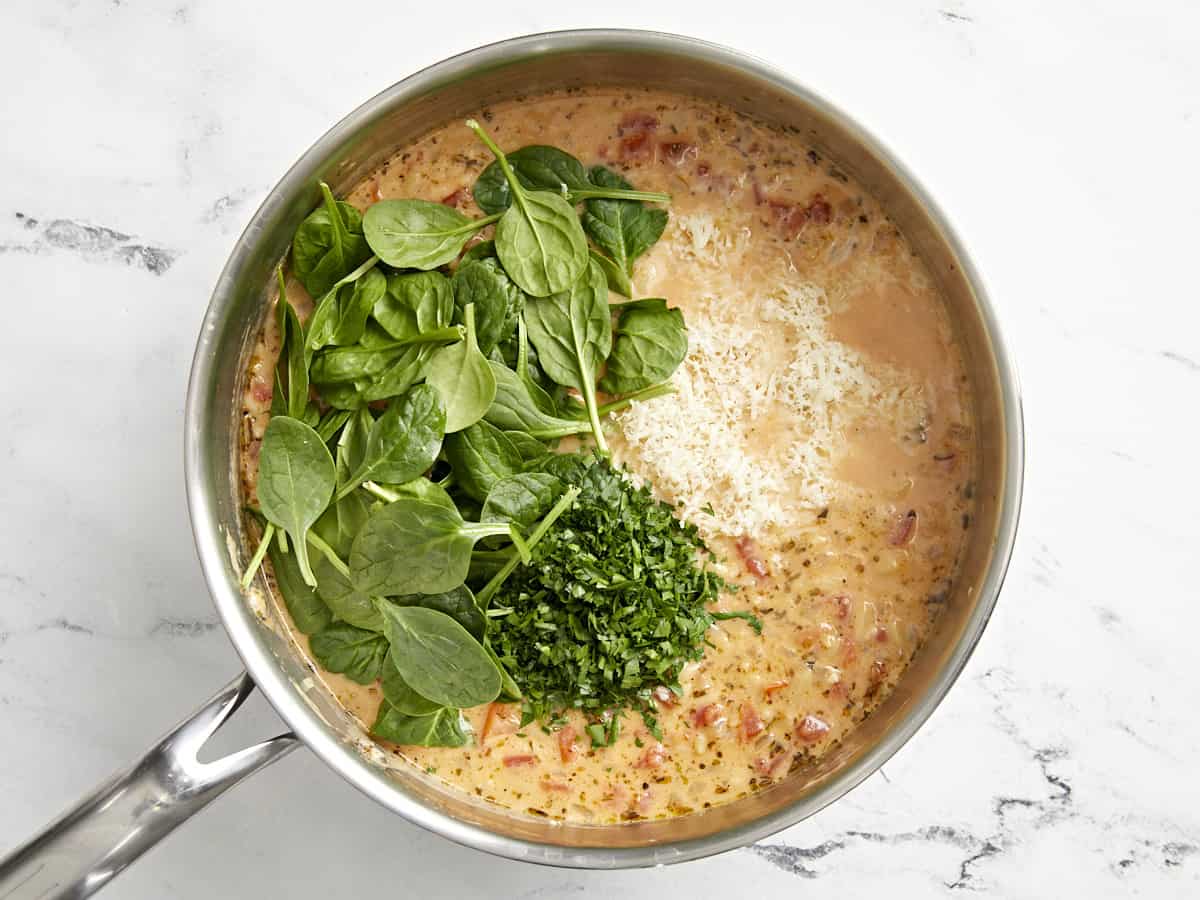 Petersilie, Spinat und Käse werden in einer Pfanne zu cremigem toskanischem Orzo gegeben.