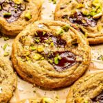 chocolate chip pistachio cookie with a puddle of chocolate on top with chopped pistachios and flakey sea salt