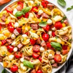 overhead view of tortellini pasta salad in a white serving bowl.