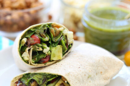 Veggie wrap, cut in half, on a white plate.