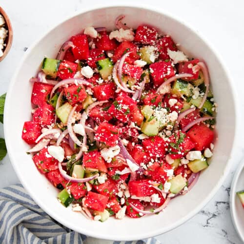 Draufsicht auf Wassermelonen-Feta-Salat in einer weißen Schüssel.