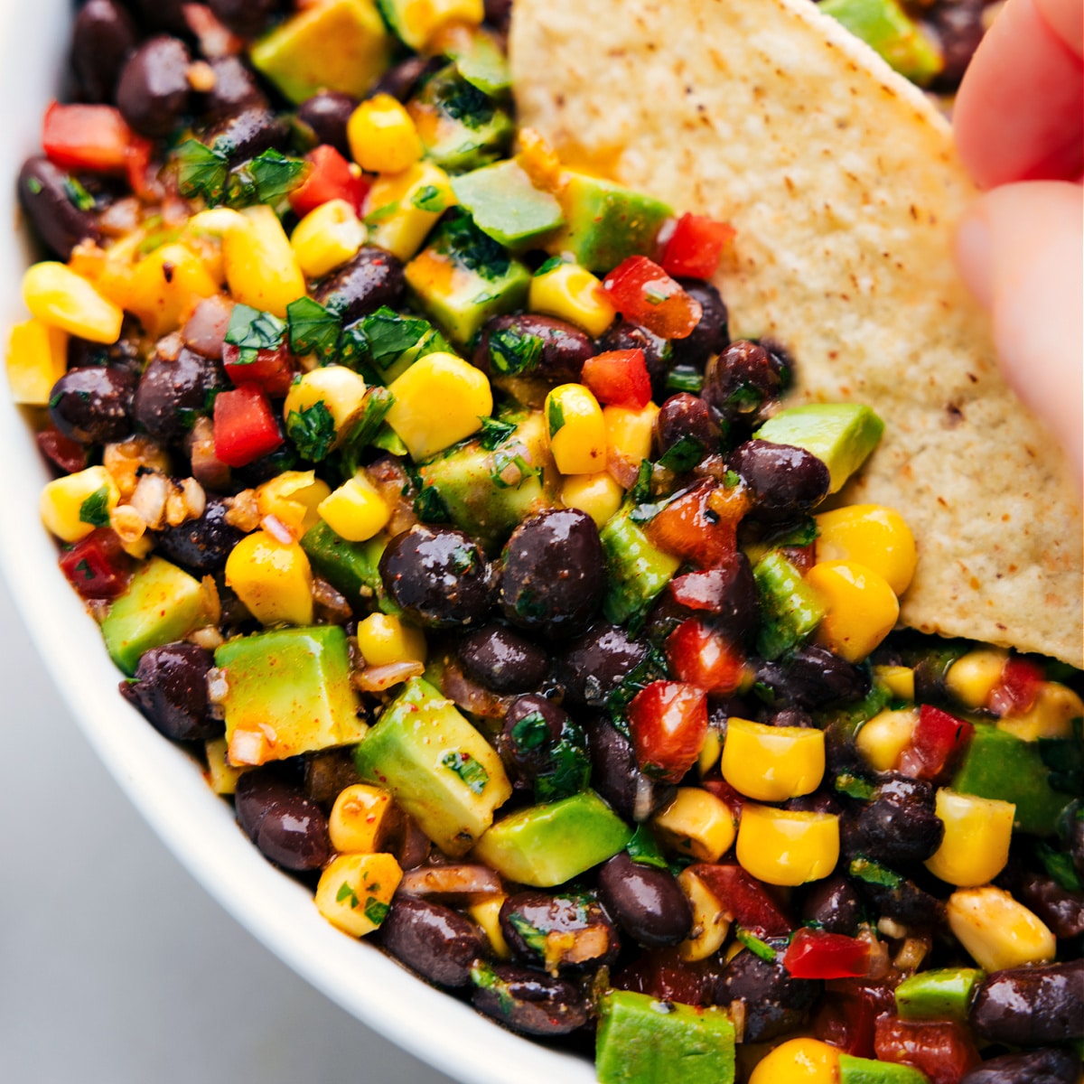 Ein Chip zum Eintauchen in den Schwarzbohnen-Mais-Avocado-Salat.