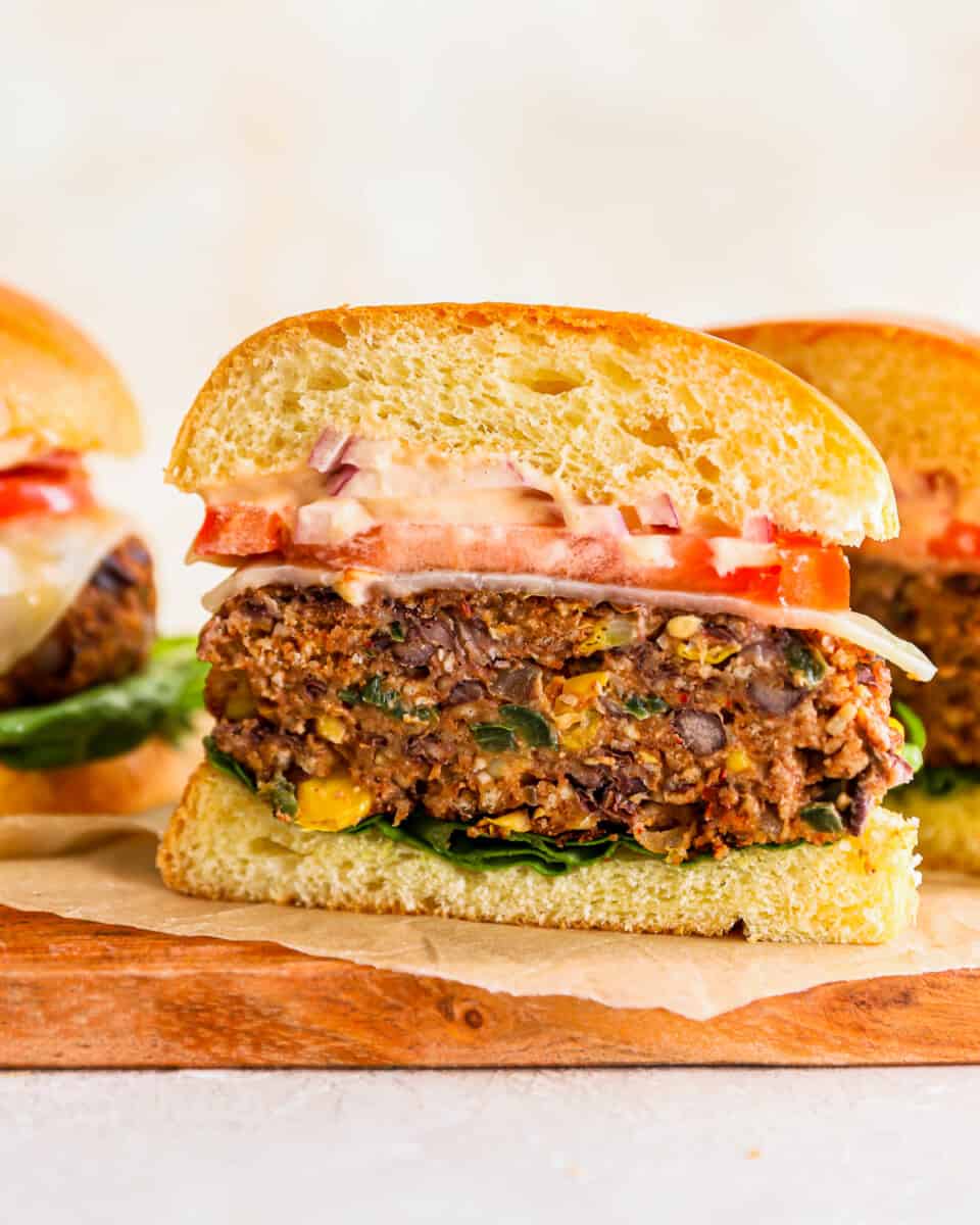 Ein vegetarischer Burger wird in zwei Hälften geschnitten, um das schwarze Bohnen-Patty zu zeigen.