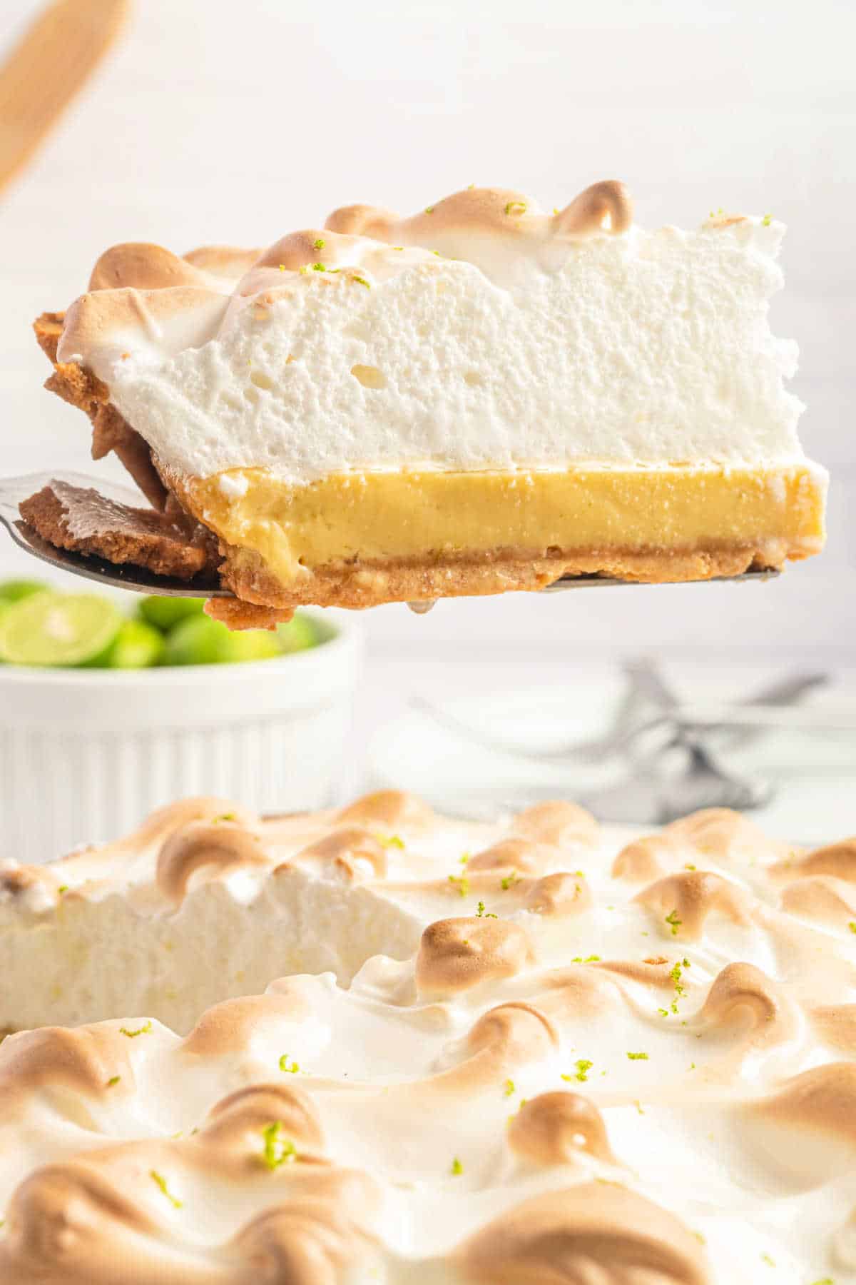 Ein Stück Key-Lime-Baiser-Kuchen wird aus der Kuchenform gehoben.