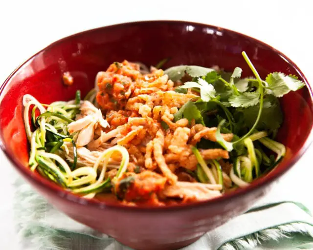 Hähnchensalat mit Salsa aus gerösteten Tomaten in roter Schüssel