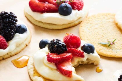 Fruit pizza cookies with one missing a bite.