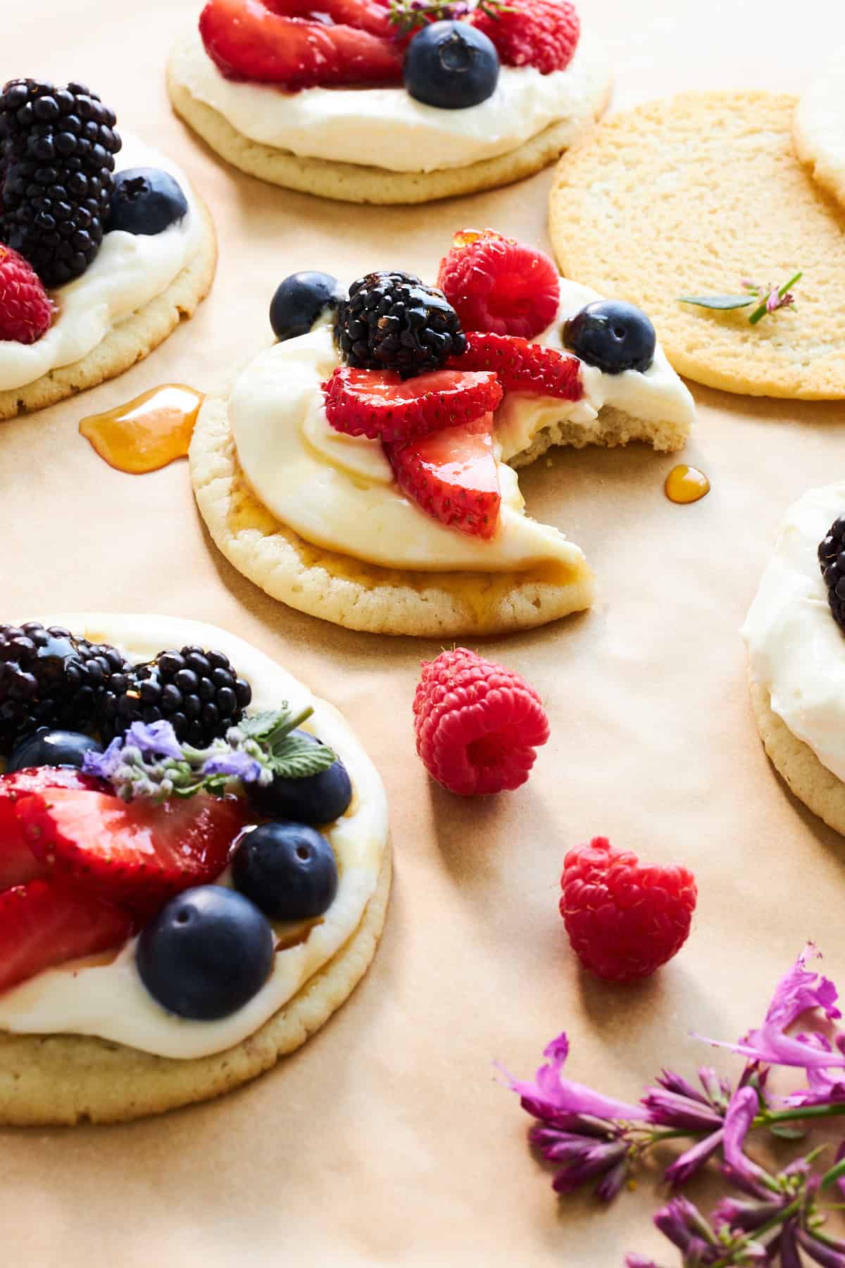 Fruit pizza cookies with one missing a bite.