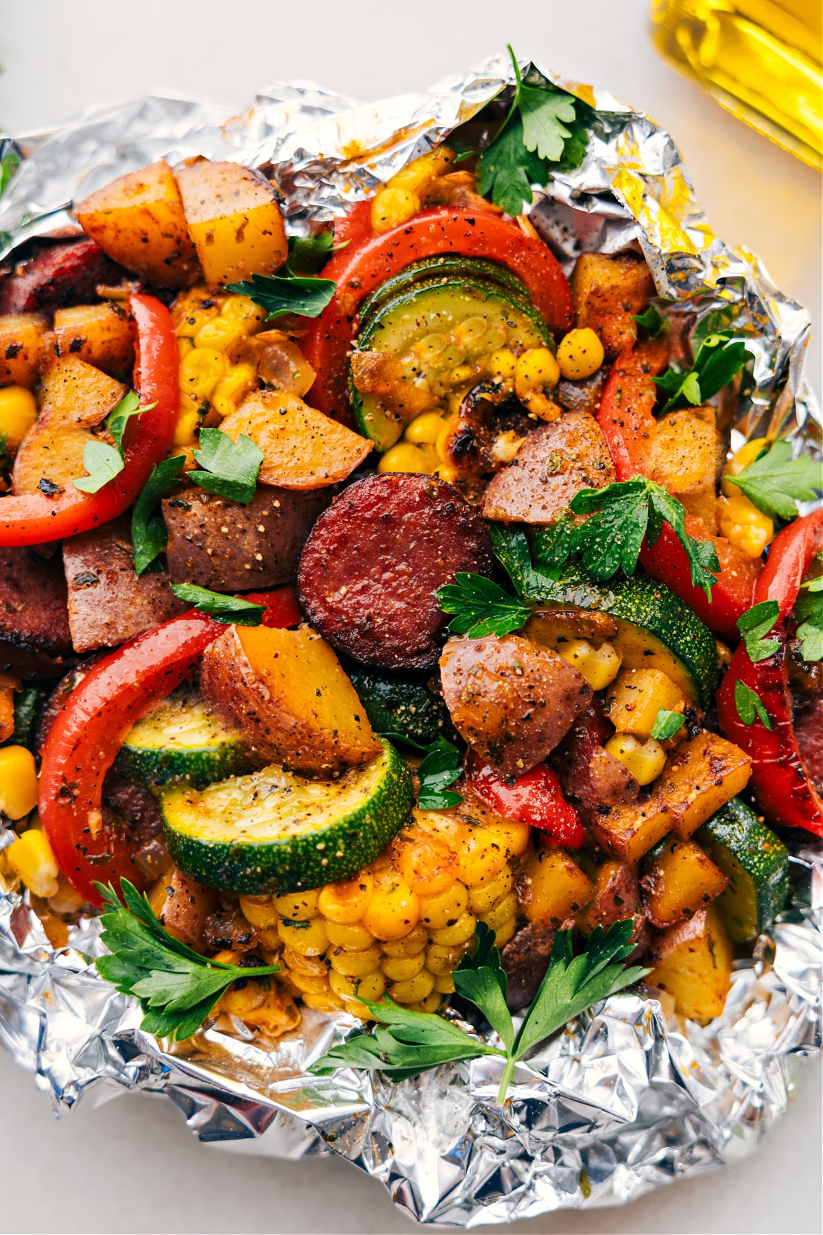 Abendessen mit Wurst und Gemüse in der Alufolie – fertig zum Verzehr, die perfekte Mahlzeit fürs Camping oder für eine unkomplizierte Mahlzeit.