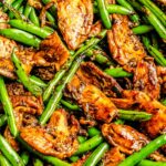 stir fry sauce coats green beans and thinly sliced chicken in the wok