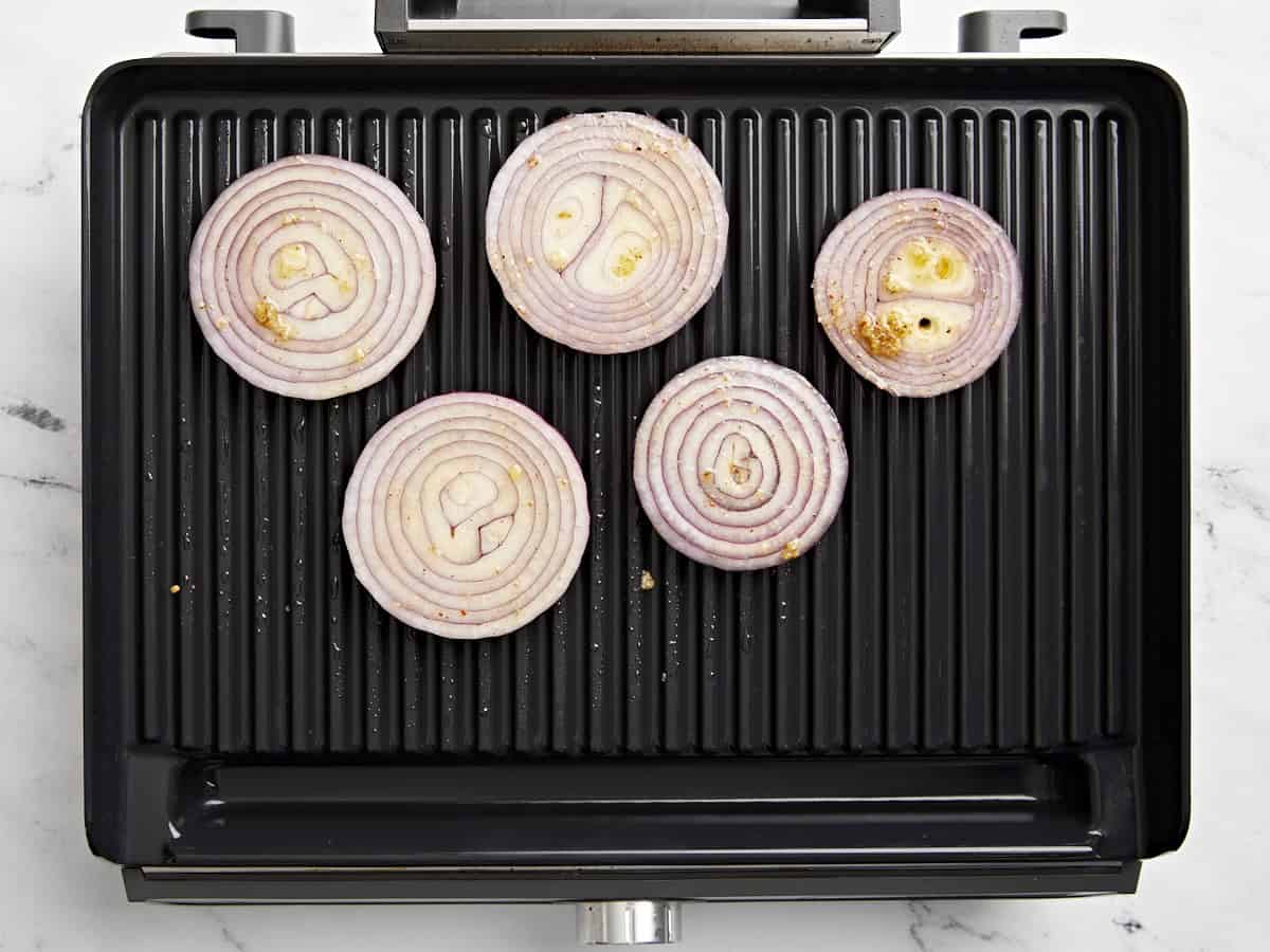 Draufsicht auf geschnittene rote Zwiebeln auf einem Grill.