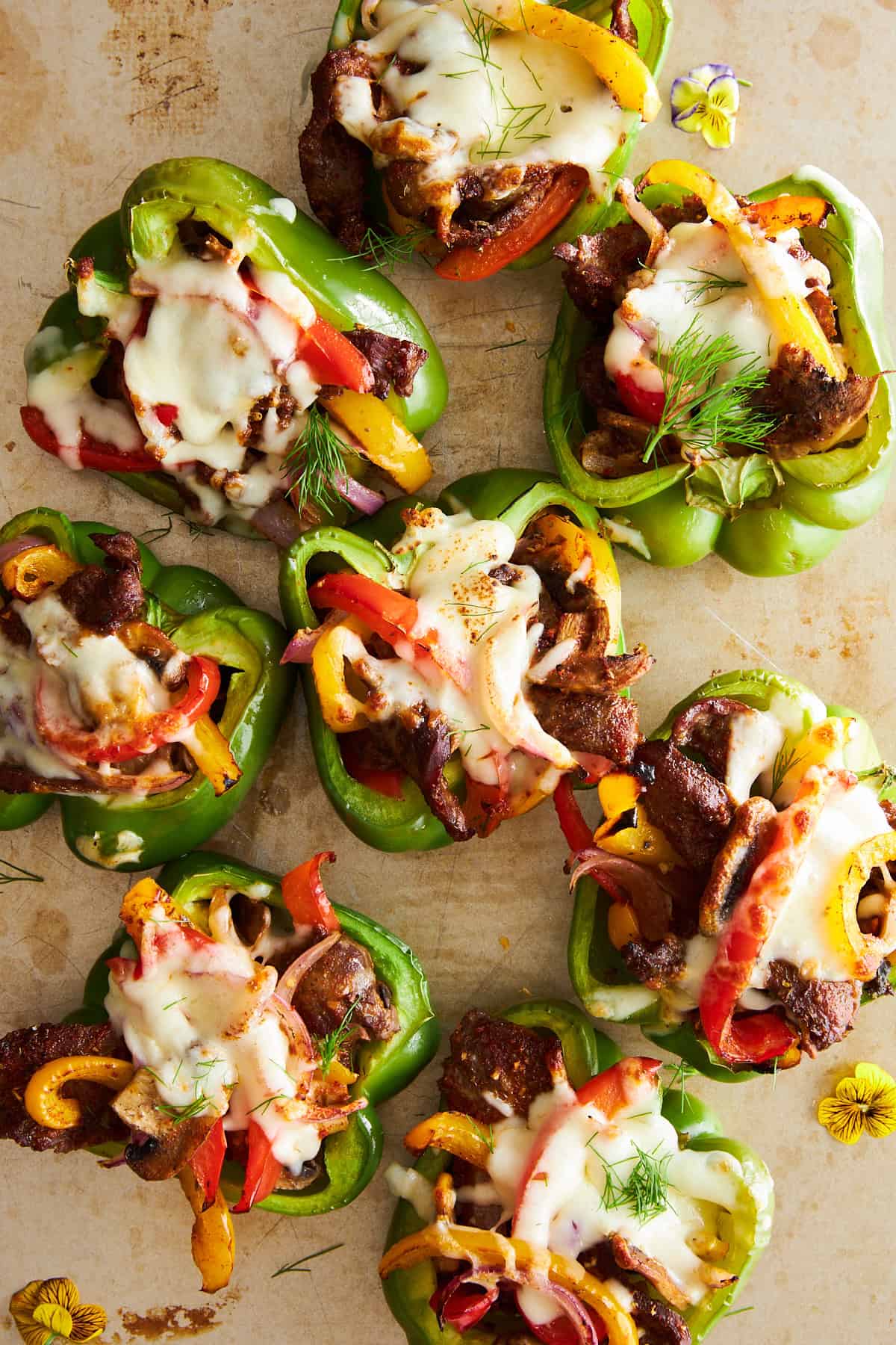 Mit Philly Cheesesteak gefüllte Paprika auf einem Backblech. 