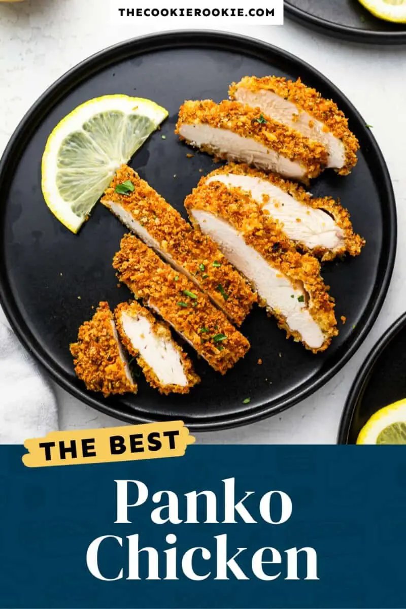 Panko-Hähnchen auf einem schwarzen Teller mit Zitronenscheiben.