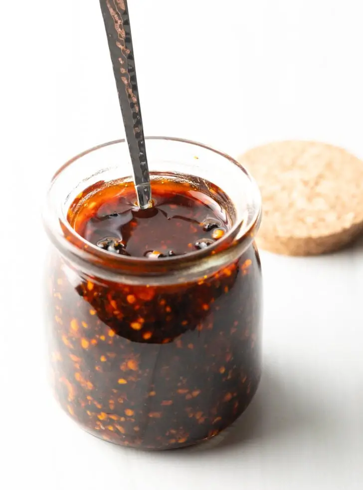 Metalllöffel in einem Glas mit hausgemachter roter Salsa de Chile de Arbol.