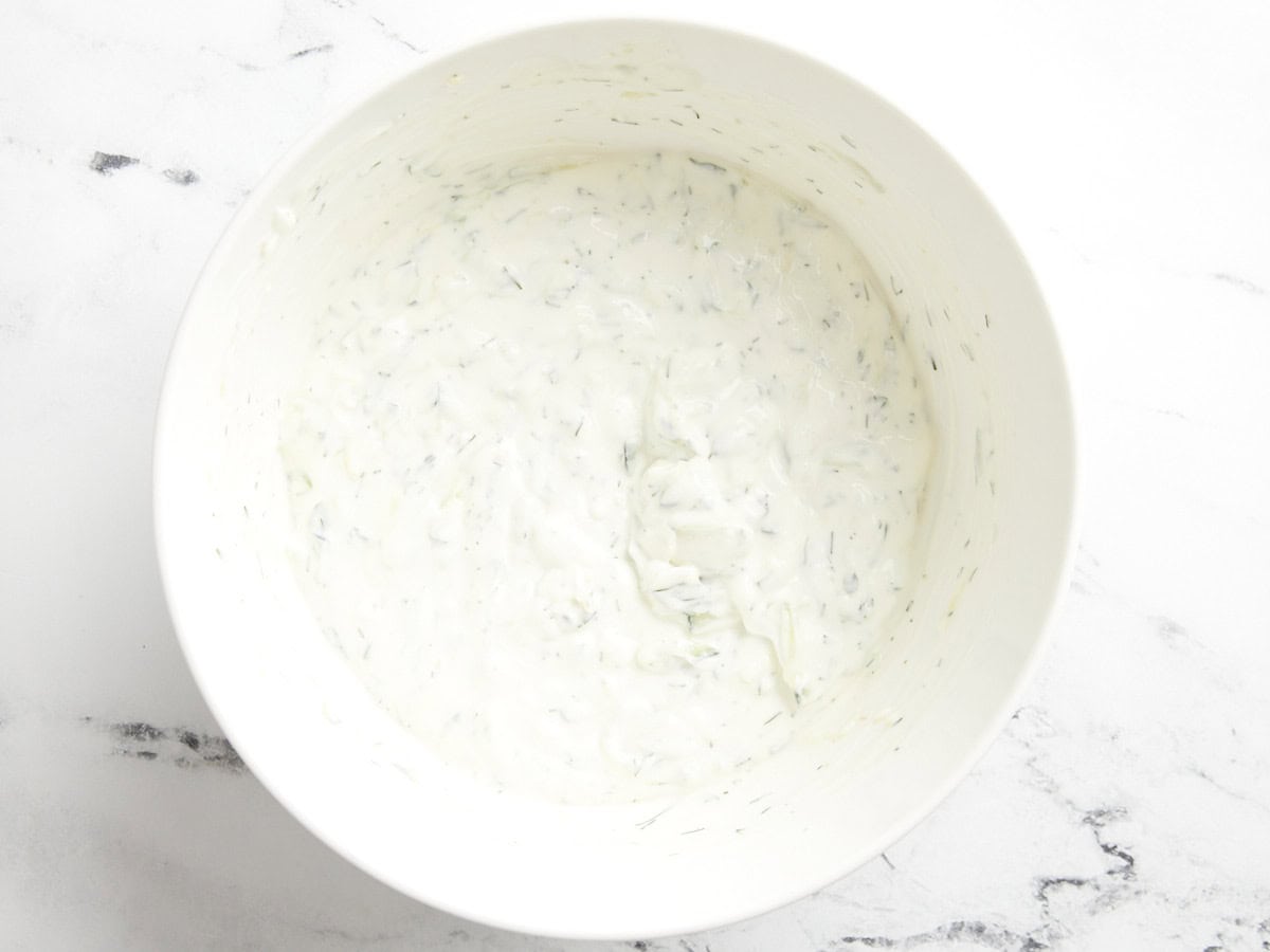 Tzatziki-Sauce in einer weißen Servierschüssel.