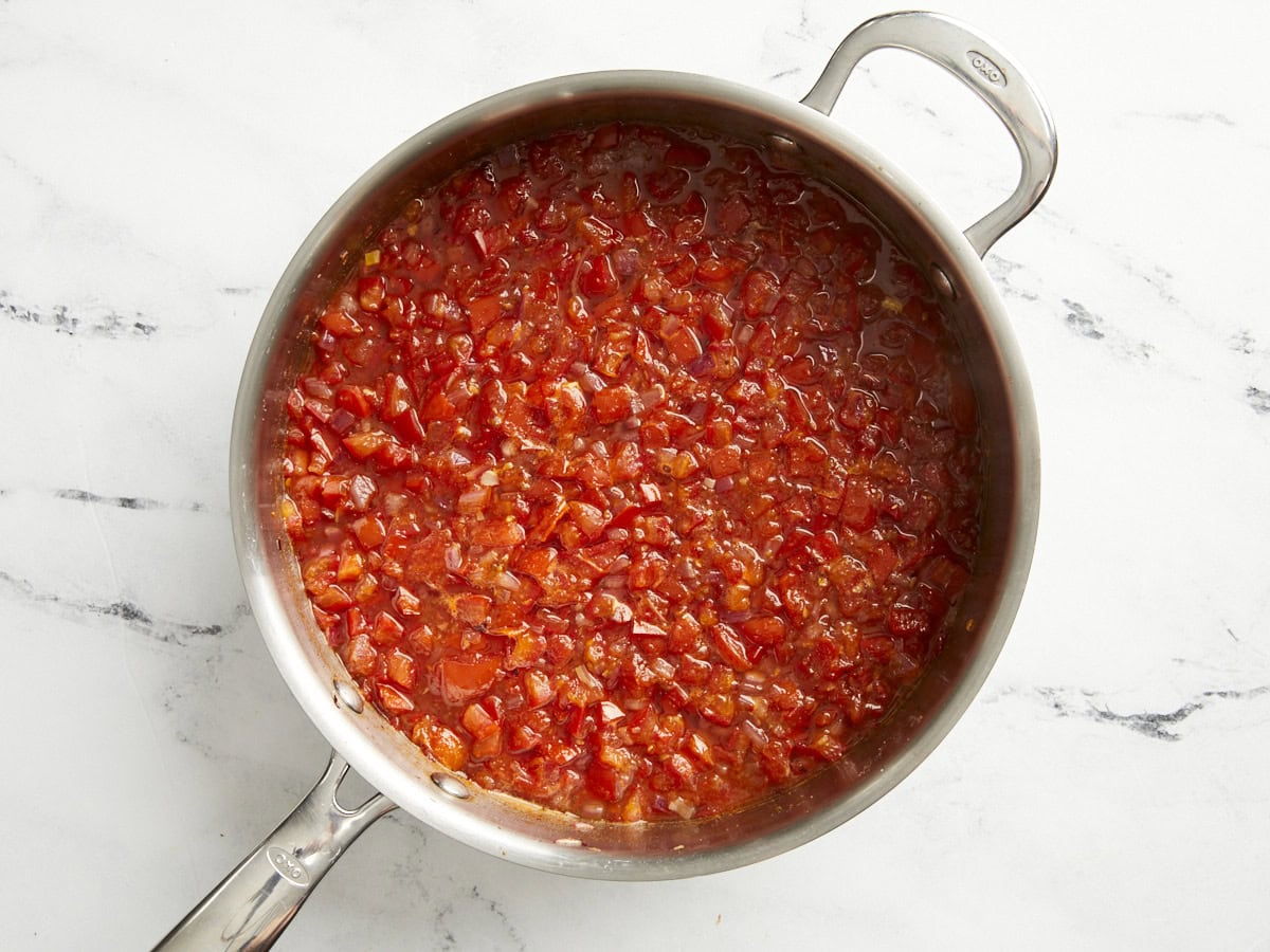 Tomatenrelish nach der Hälfte der Garzeit in einer Pfanne erhitzen.