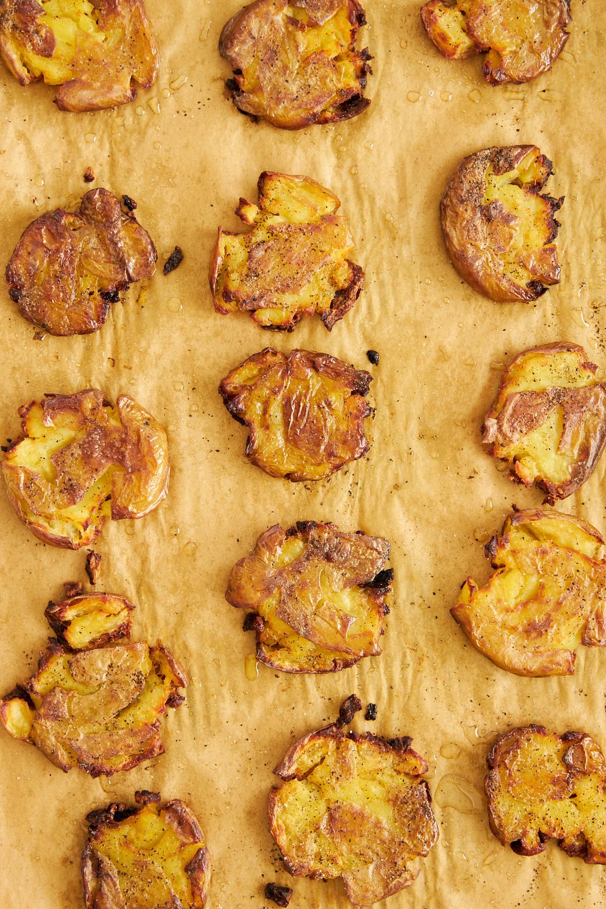 Knusprig gebackene Kartoffeln auf einem mit Backpapier ausgelegten Backblech. 