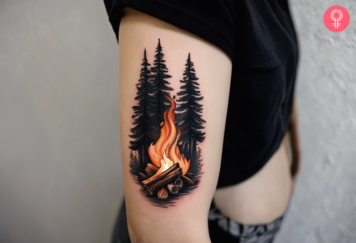 Frau mit Wald-Lagerfeuer-Tattoo auf dem Oberarm