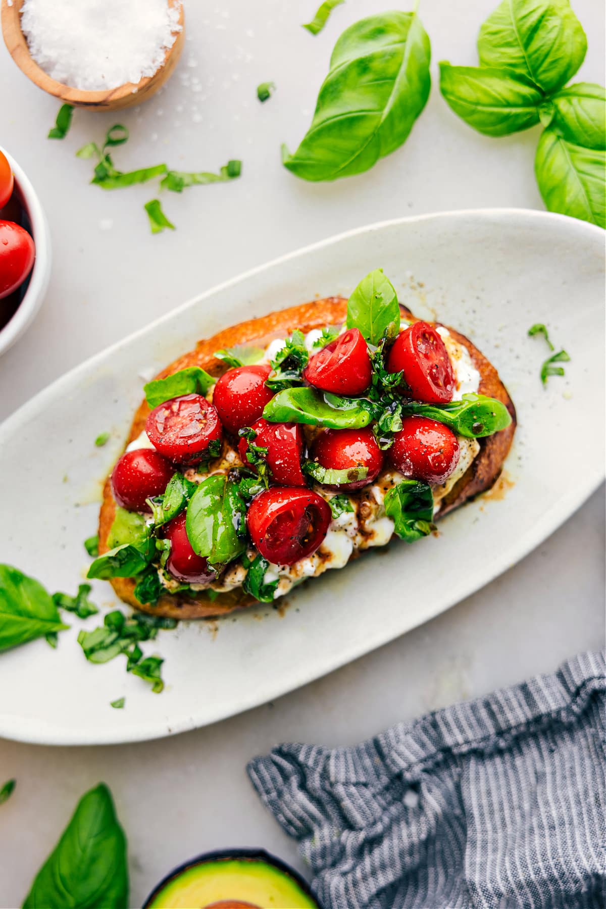 Hüttenkäse-Toast auf einem Teller mit frischem Basilikum und Balsamico.