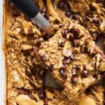 A baked oatmeal bar being lifted from the pan.