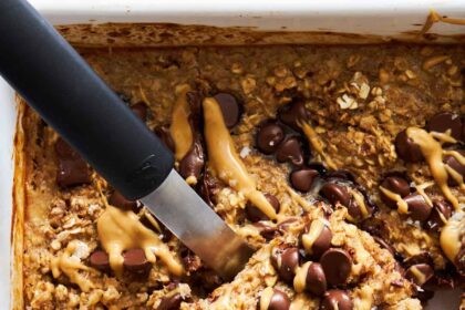 A baked oatmeal bar being lifted from the pan.