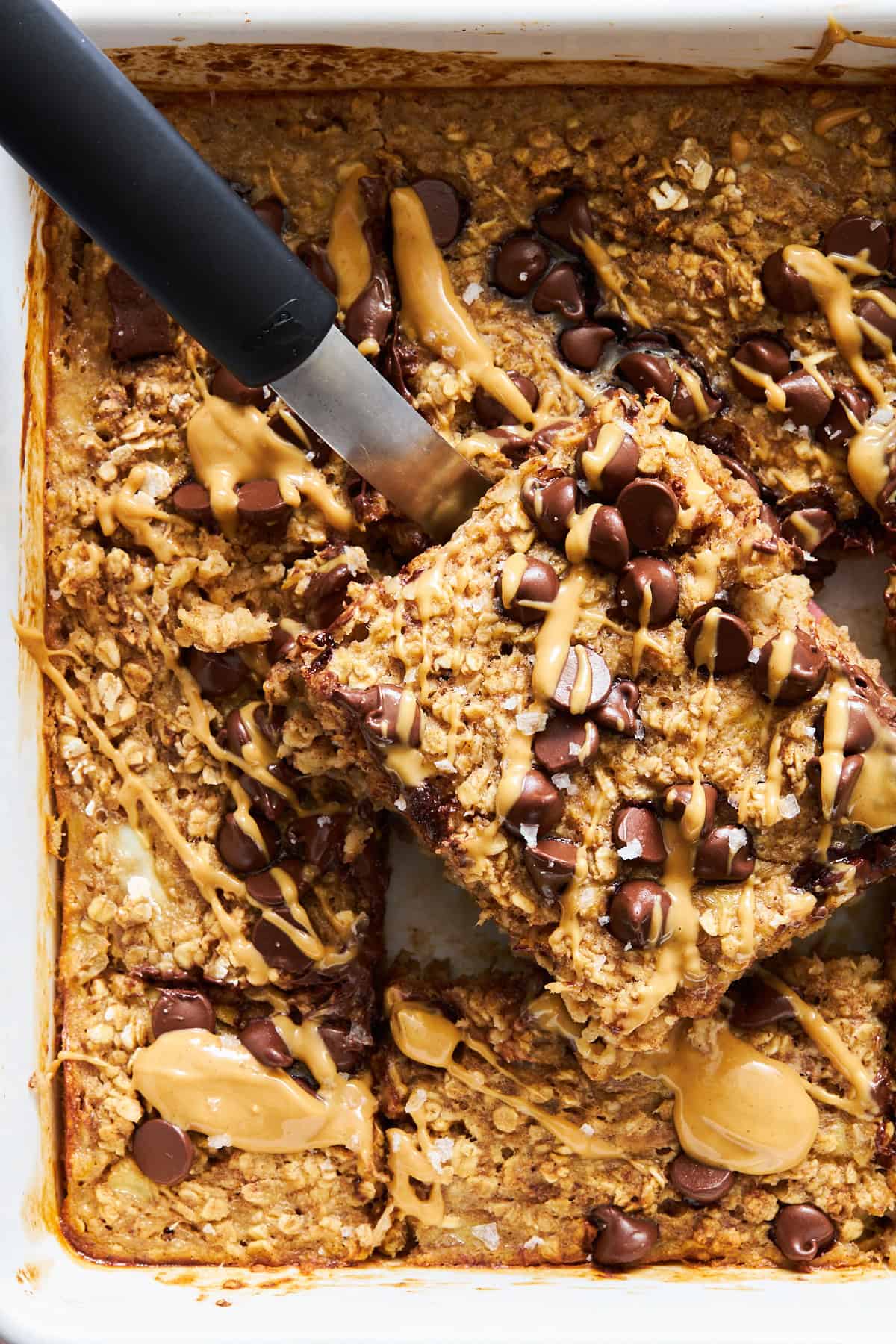 A baked oatmeal bar being lifted from the pan.