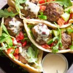 Pita pockets stuffed with tomato and cucumber salad, beef meatballs, and tzatziki.