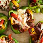 Philly cheesesteak stuffed peppers on a baking sheet.