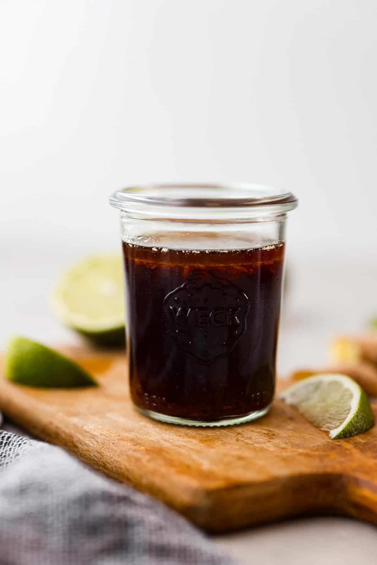 Side shot of a small glass jar with poke sauce in it.