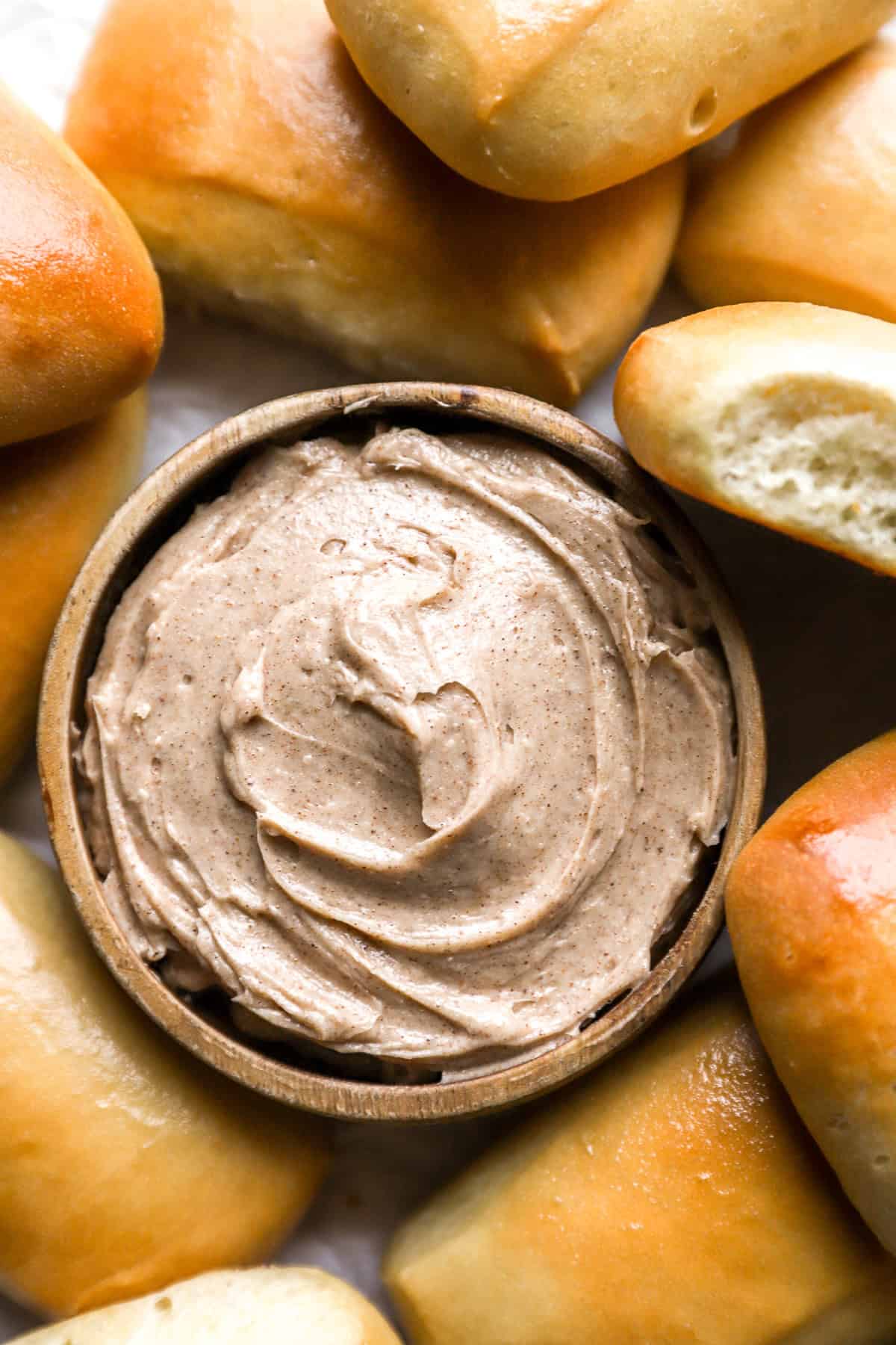 Draufsicht auf Texas Roadhouse: Honig-Zimt-Butter in einer Schüssel, umgeben von Brötchen.