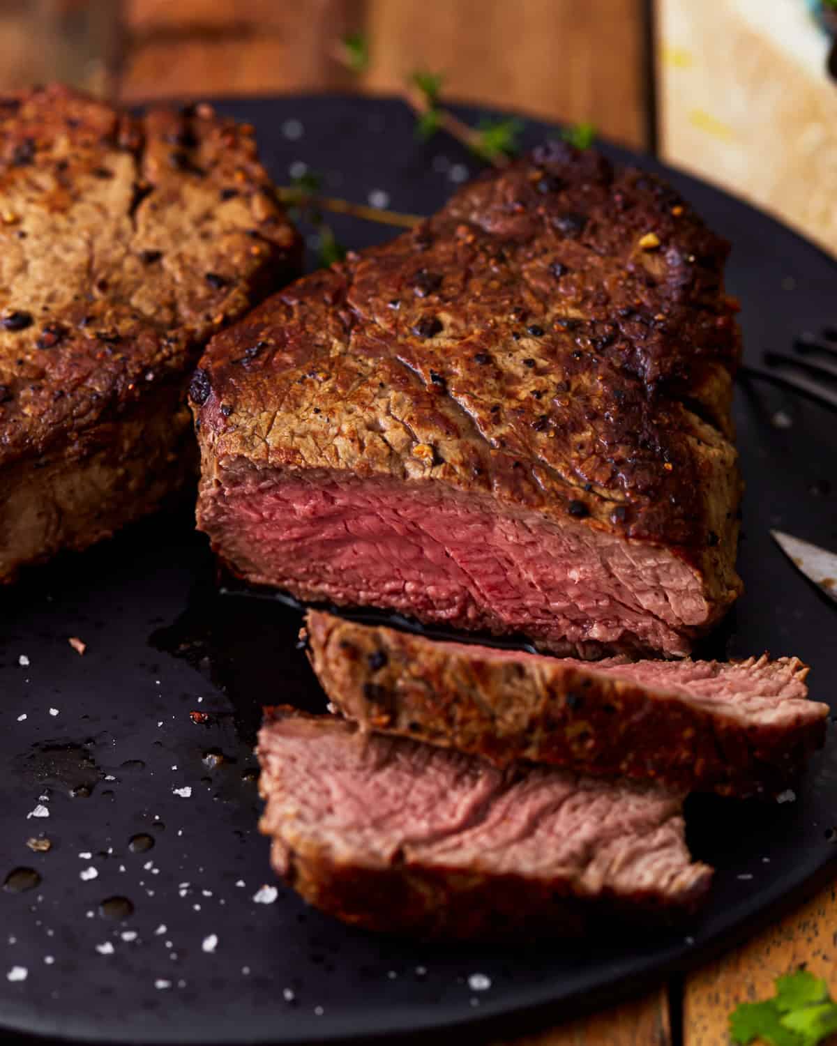 Dreiviertelansicht eines teilweise aufgeschnittenen, medium rare gegarten Filet Mignon.