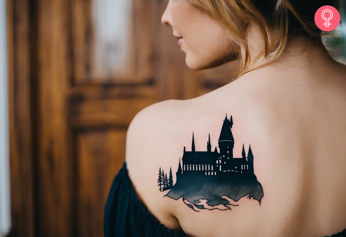 Eine Frau mit einem Hogwarts-Silhouette-Tattoo auf ihrer Schulter